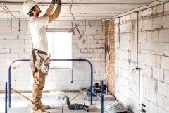 electrician-installer-with-tool-his-hands-working-with-cable-construction-site-1